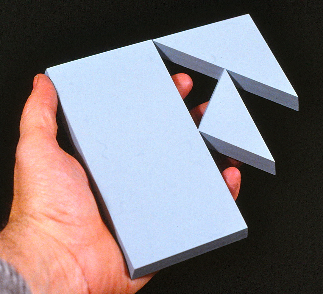 Photo of a left hand holding a large letter F that was cast aluminum.