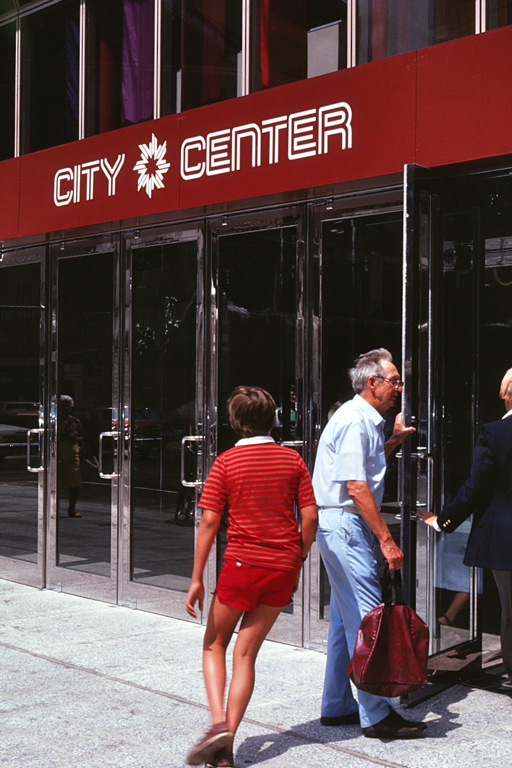 People entering through the doors into the retail mall.