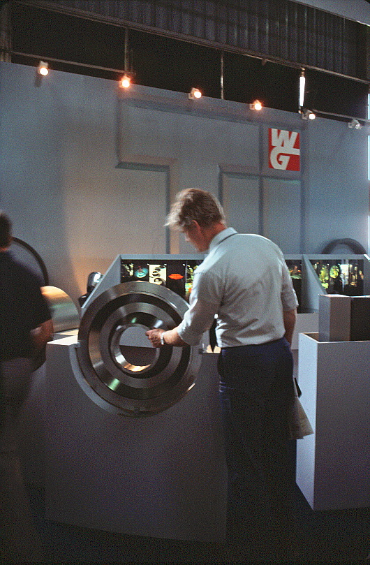 A man inspecting a large, circular metal part.